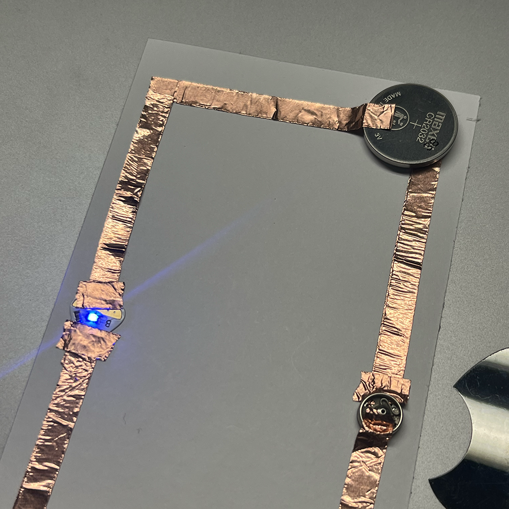 Making test of low voltage electricity using metal button close in detail.